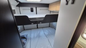 Un espacio acogedor para descansar después de un día de ruta. Dos camas cómodas, iluminación LED ambiental y almacenamiento optimizado.